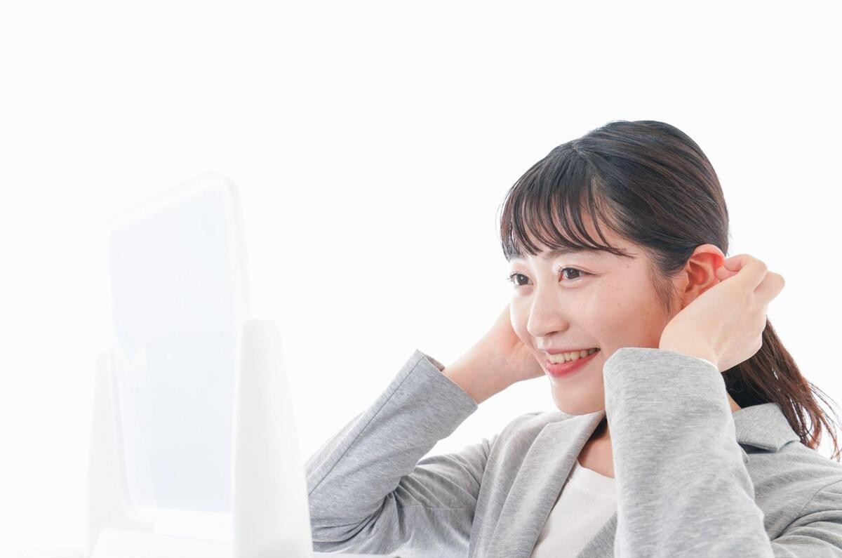 鏡を見て笑顔の女性