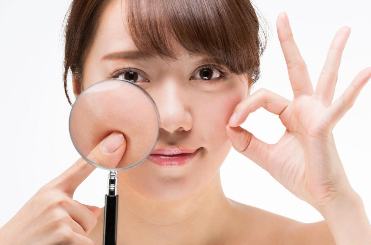 虫眼鏡で頬の毛穴を拡大表示している