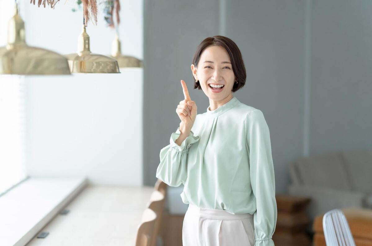 人差し指を立てて笑顔を向ける女性