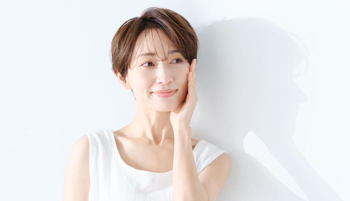 頬に手をあてて微笑む女性